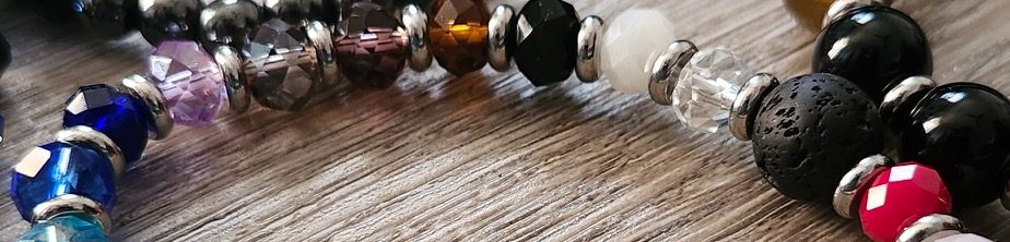 Colorful beaded bracelets arranged on a wooden surface.